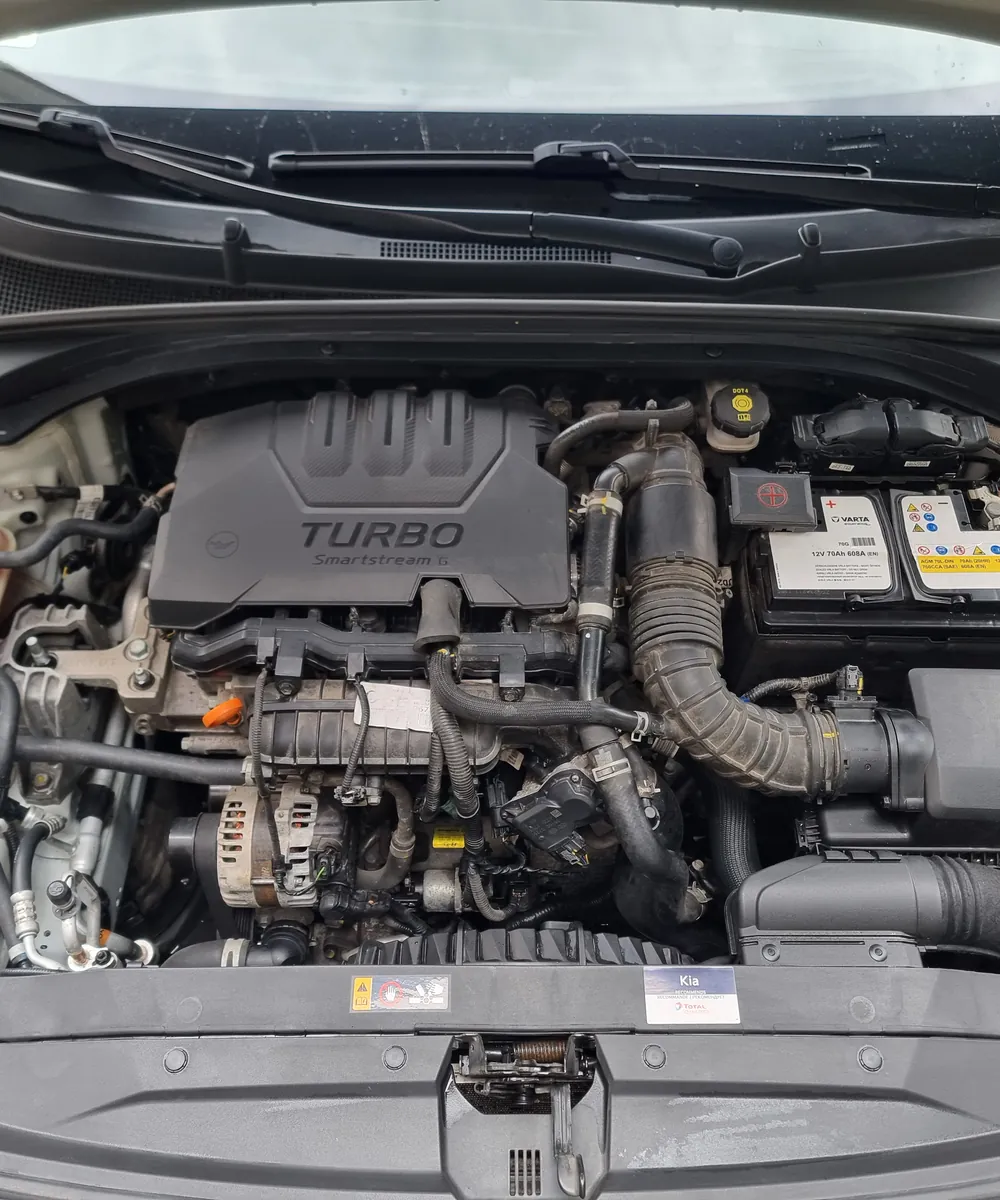 Nyitott motorháztető alatt egy turbós benzinmotor, átvizsgálás közben